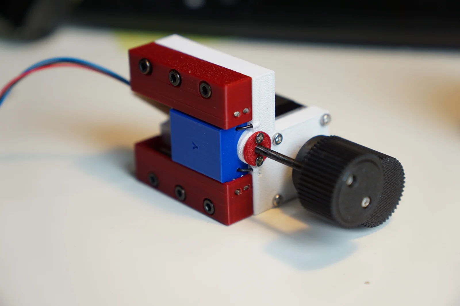 Completed NEMA 11 single-axis stage module with printed 1:1 gears and an M3 lead screw